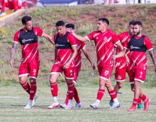 Imagem jogares com camisa vermelha em campo