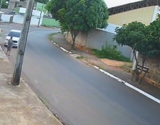 Imagem mulher caminhando próximo a calçada e carro vindo atrás