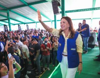 Imagem mulher sorridente com o braço direito erguido