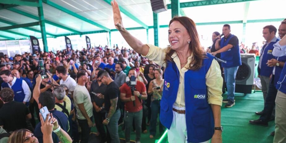 Imagem mulher sorridente com o braço direito erguido