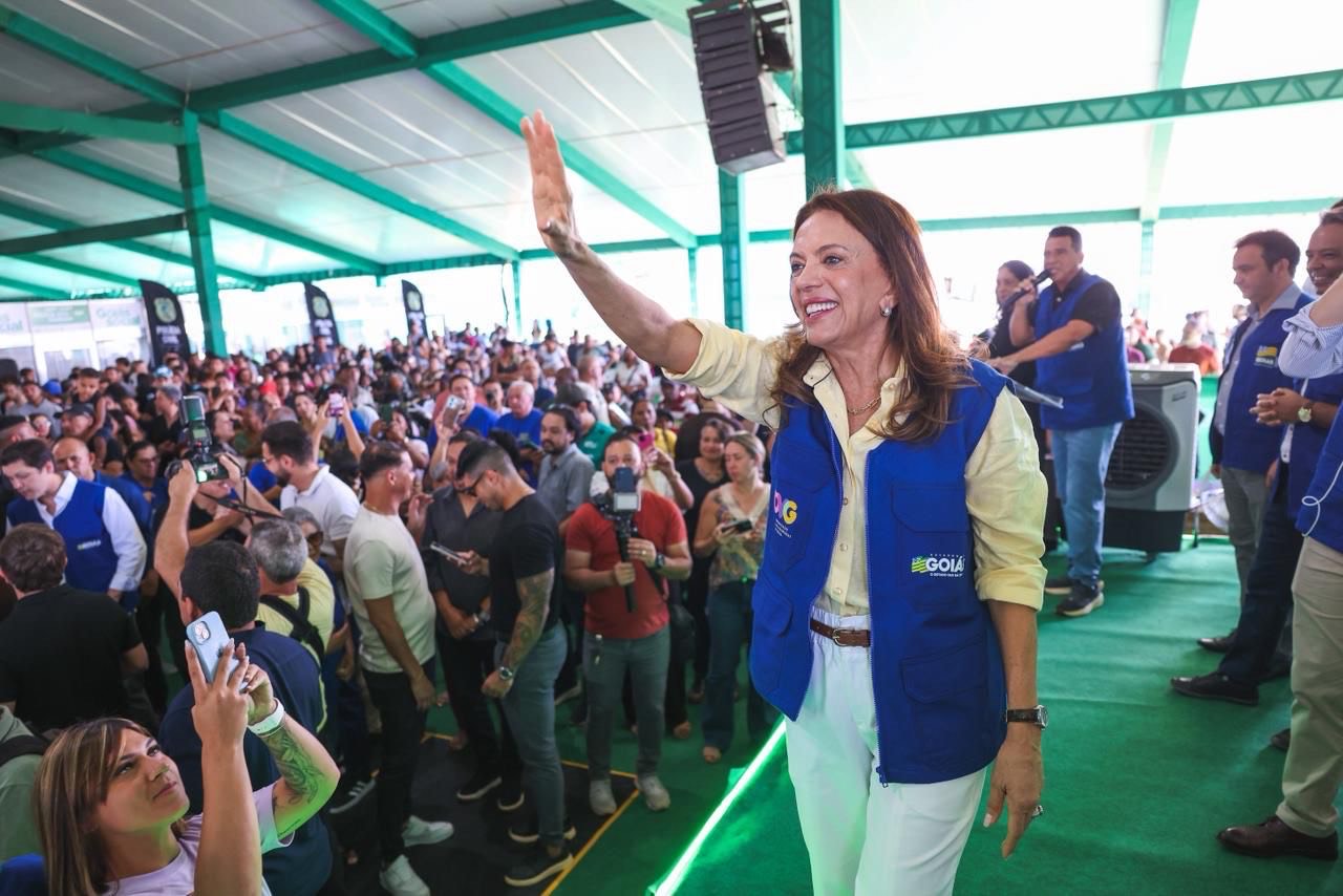 Imagem mulher sorridente com o braço direito erguido