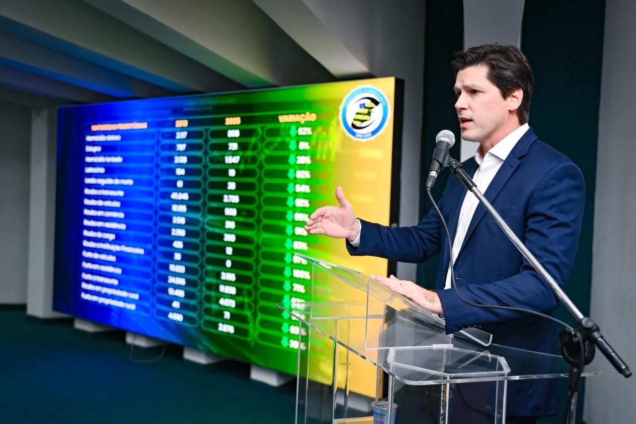 Imagem homem de terno preto falando ao microfone