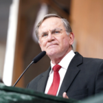 Imagem homem de terno preto e gravata vermelha