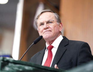 Imagem homem de terno preto e gravata vermelha