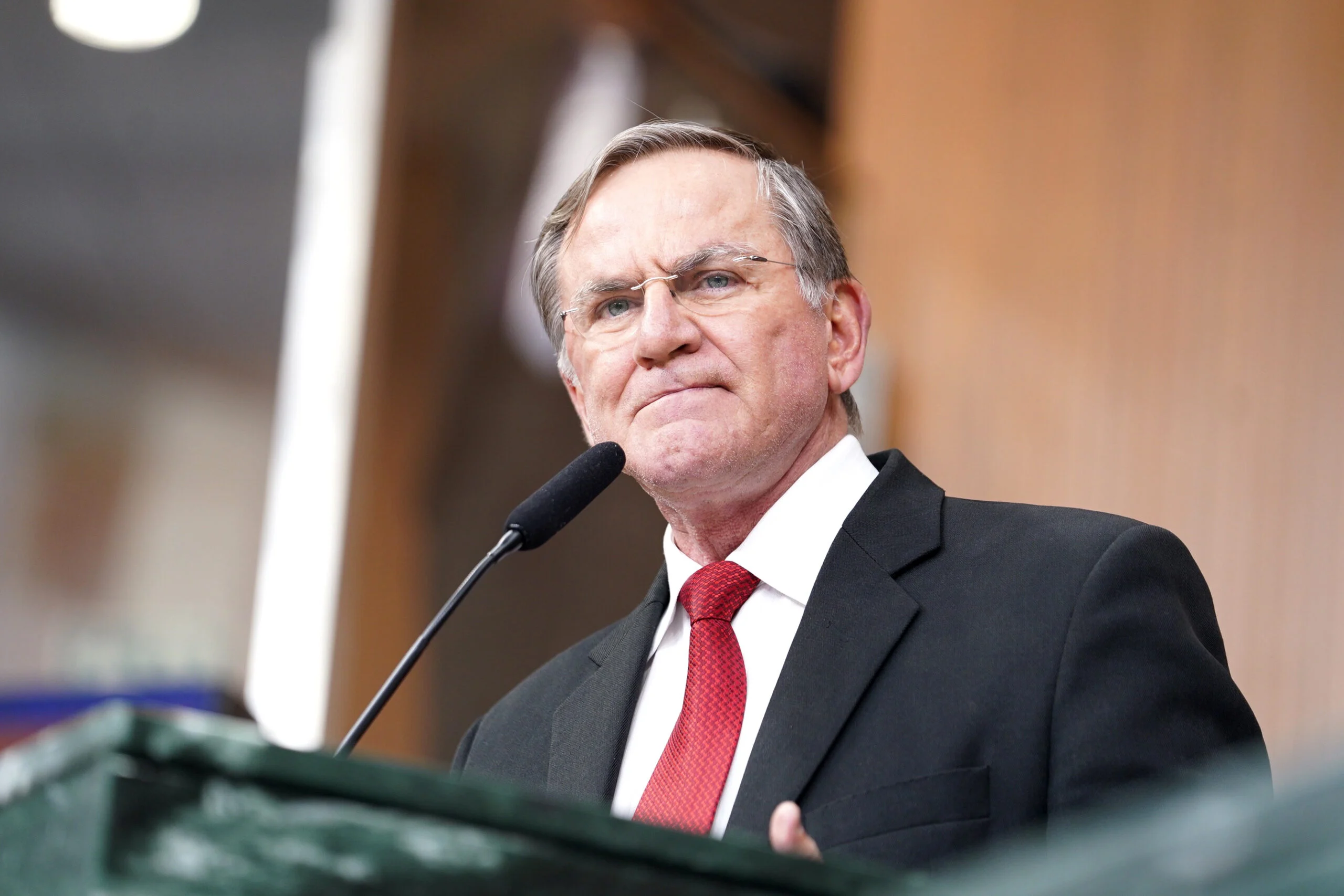 Imagem homem de terno preto e gravata vermelha