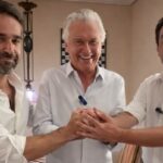 Imagem três homens de camisa branca com as mãos dadas para frente