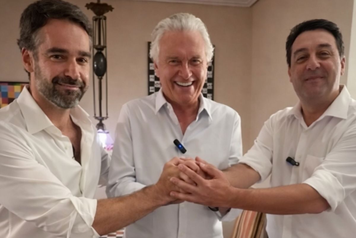 Imagem três homens de camisa branca com as mãos dadas para frente