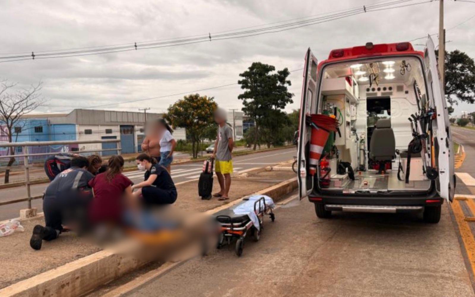 Imagem atendimento pessoa caída ao lado ambulância de socorro