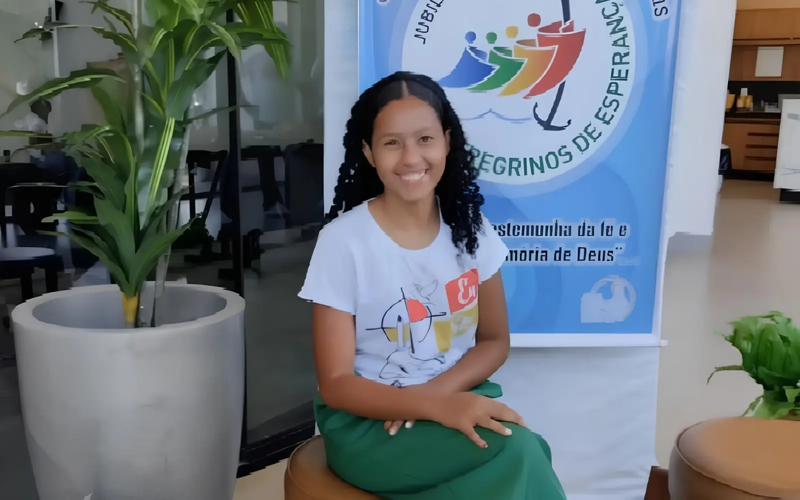 Imagem jovem sorrindo camisa branca e calça verde