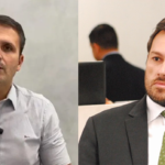 Imagem dois homens primeiro de camisa branca e o segundo de terno preto e gravata verde