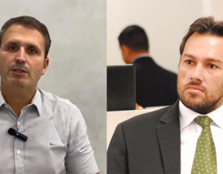 Imagem dois homens primeiro de camisa branca e o segundo de terno preto e gravata verde