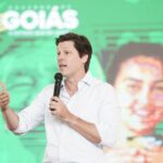 Imagem homem de camisa branca falando ao microfone