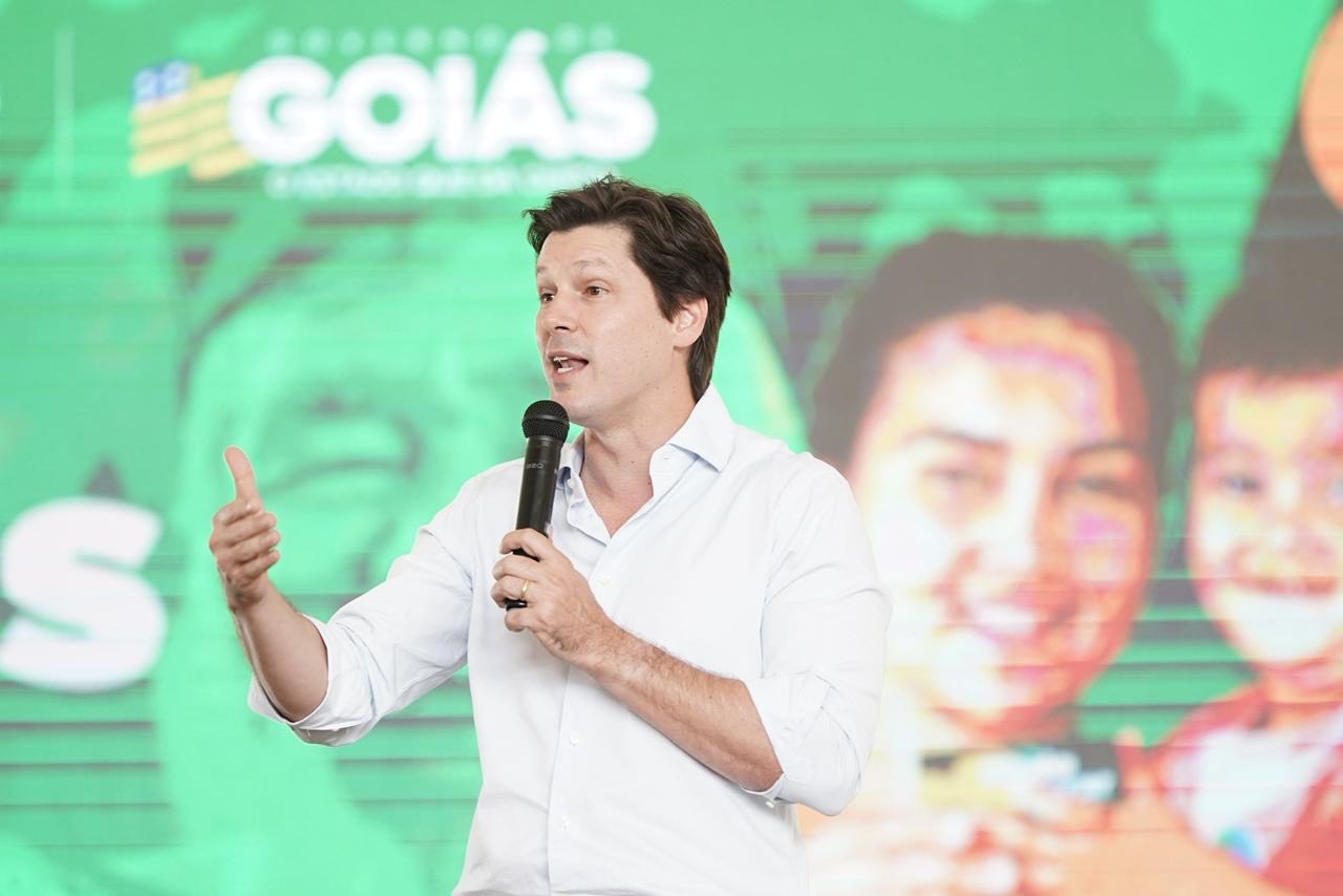 Imagem homem de camisa branca falando ao microfone