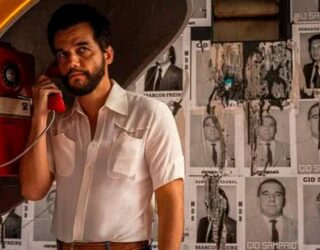 Imagem homem segurando telefone em um orelhão