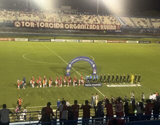 Imagem jogadores no centro do gramado em fila