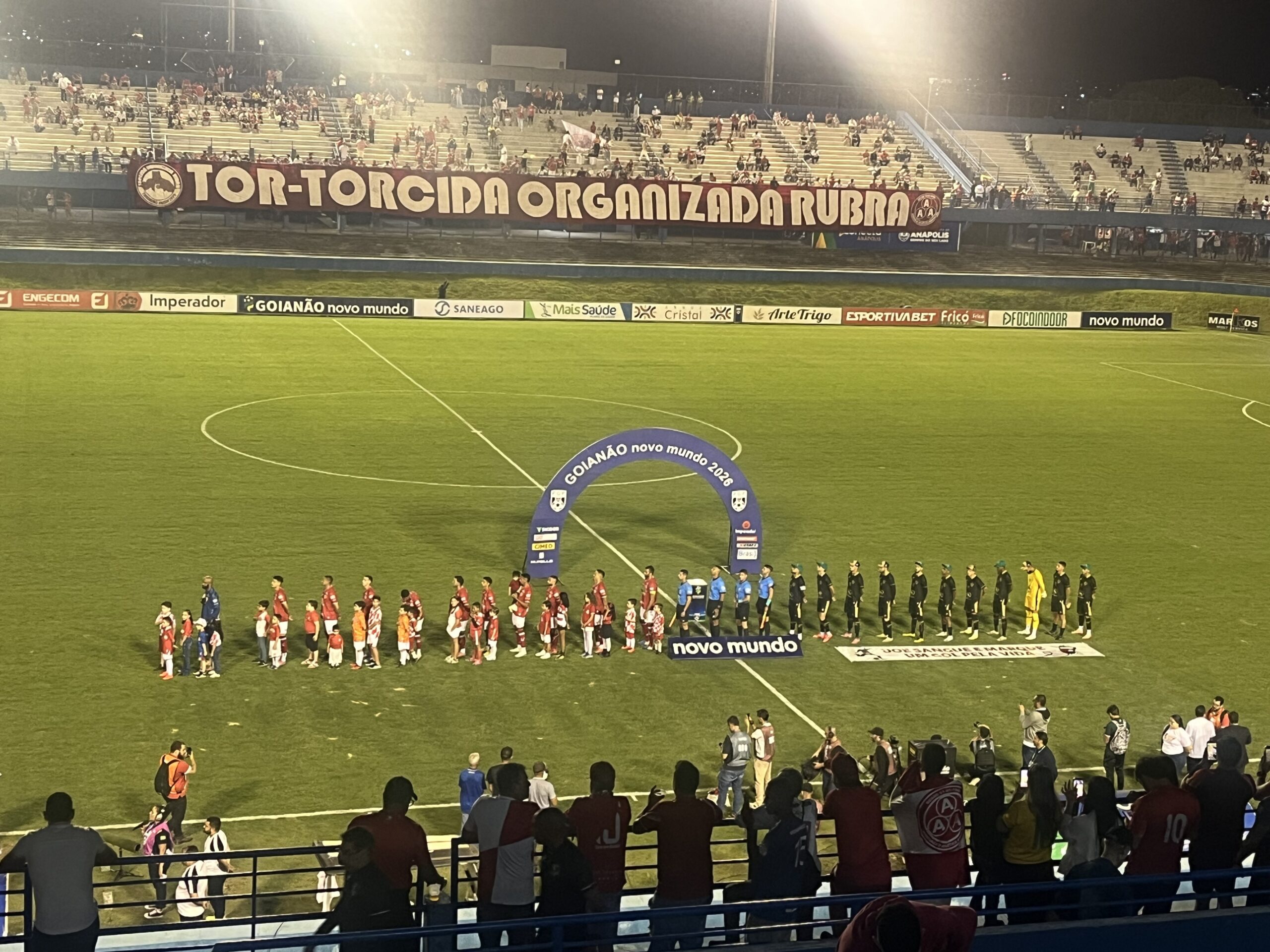 Imagem jogadores no centro do gramado em fila
