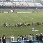 Imagem jogadores perfilados no meio do gramado