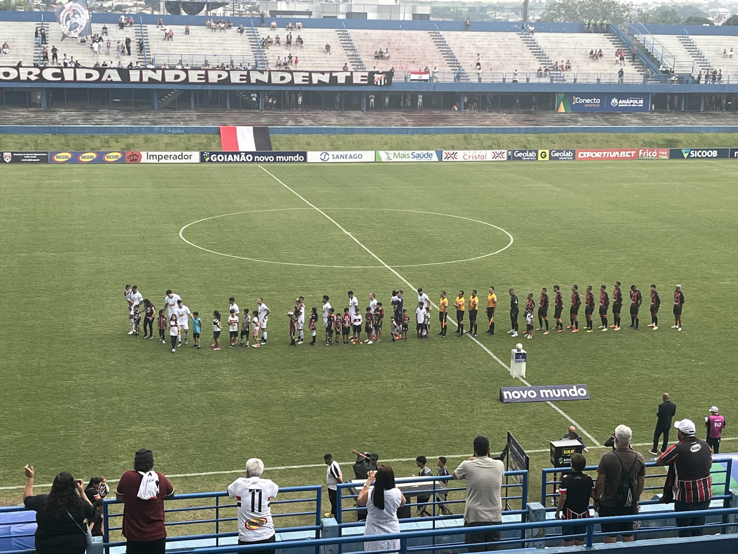 Imagem jogadores perfilados no meio do gramado