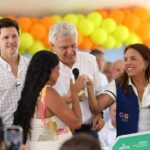 Imagem homem segurando microfone pessoas proximas