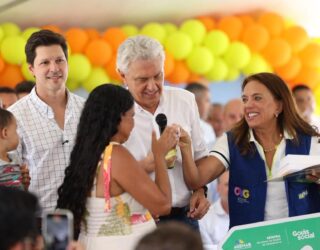 Imagem homem segurando microfone pessoas proximas