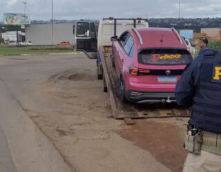 Imagem carro cor de rosa sendo colado no guincho