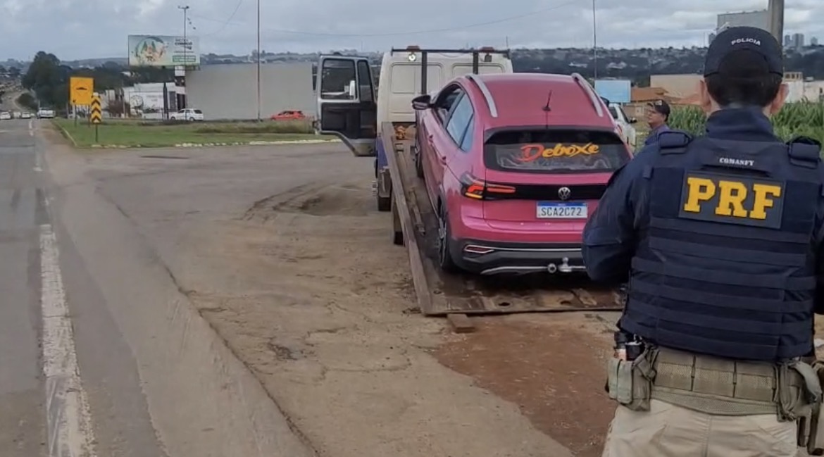 Imagem carro cor de rosa sendo colado no guincho