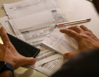 Imagem mãos caneta e papeis