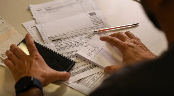 Imagem mãos caneta e papeis