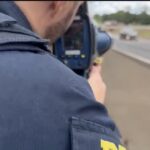 Imagem policial segurando aparelho eletronico