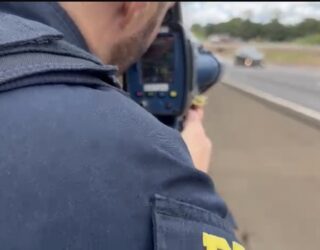 Imagem policial segurando aparelho eletronico