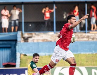 Imagem goleiro sentado e atacante em pé comemorando