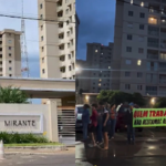 Imagem predio ao lado pessoas segurando uma faixa em protesto
