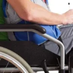 Imagem pessoa na cadeira de rodas escrevendo no caderno