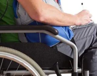 Imagem pessoa na cadeira de rodas escrevendo no caderno