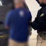 Imagem homem sendo conduzido pela policia