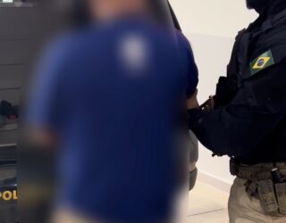 Imagem homem sendo conduzido pela policia