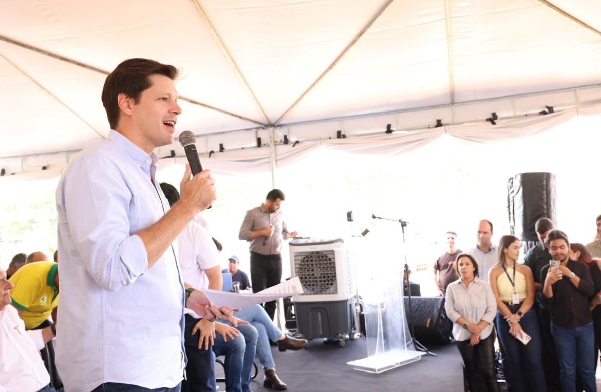 Imagem homem de camisa branca falando ao microfone