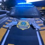 Imagem capô de carro da policia com notas em cima