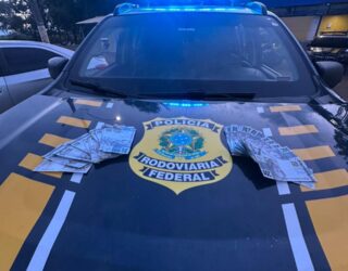 Imagem capô de carro da policia com notas em cima