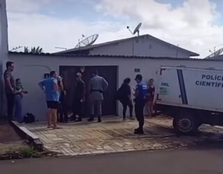 Imagem policiais e pessoas em frente uma casa