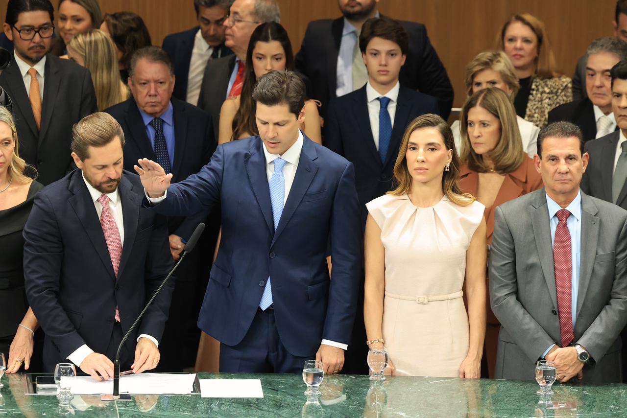 Imagem homem com braço erguido ao fundo varias pessoas