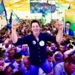 Imagem homem sorrindo com os braços erguidos