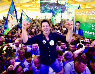 Imagem homem sorrindo com os braços erguidos