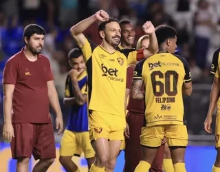 Imagem jogadores com camisa amarela comemorando ao fundo jogadores com camisa grena