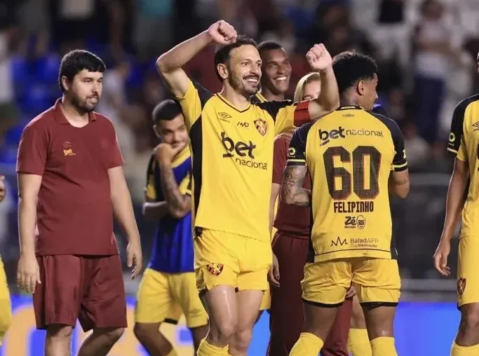Imagem jogadores com camisa amarela comemorando ao fundo jogadores com camisa grena