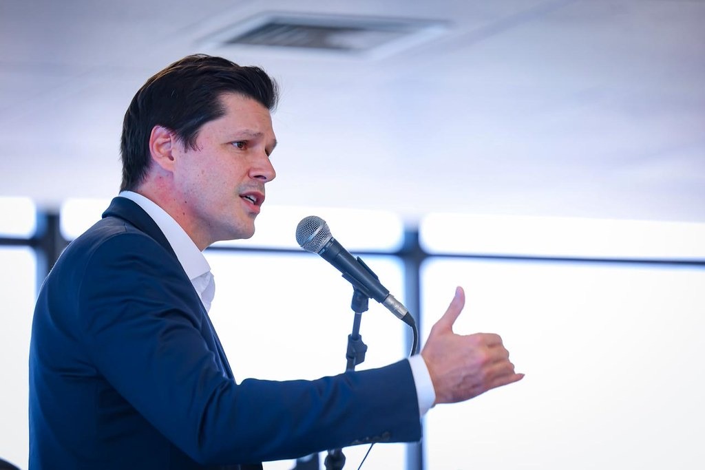 Imagem homem de terno falando ao microfone