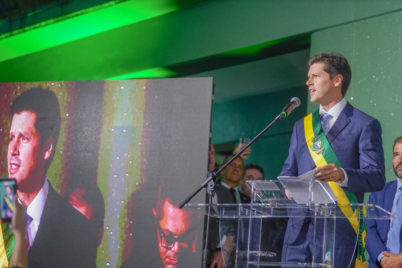 Imagem homem de terno e gravata falando no microfone