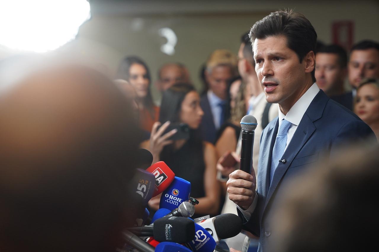 Imagem homem segurando microfone em entrevista coletiva