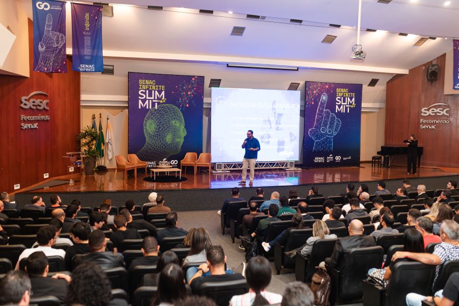 Imagem homem em palco e publico em teatro lotado