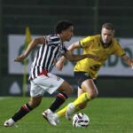 Imagem jogadores disputando a bola em campo gramado